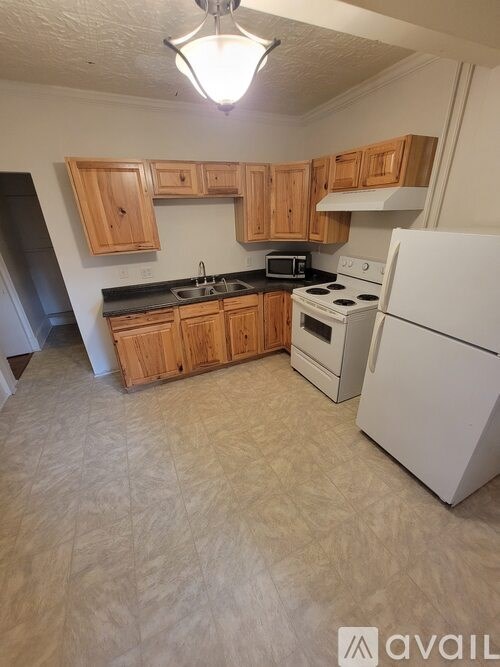 A kitchen with wooden cabinets and white appliances.