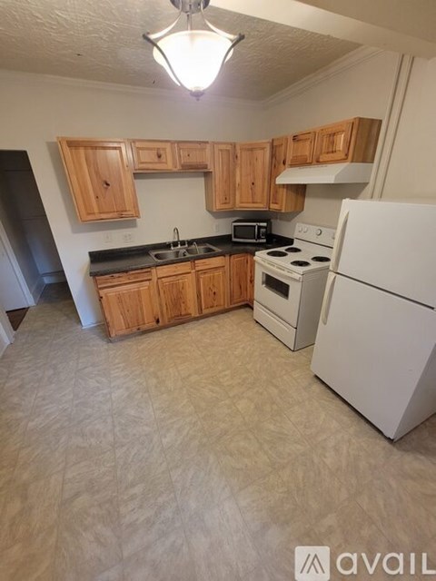 A kitchen with wooden cabinets and white appliances.