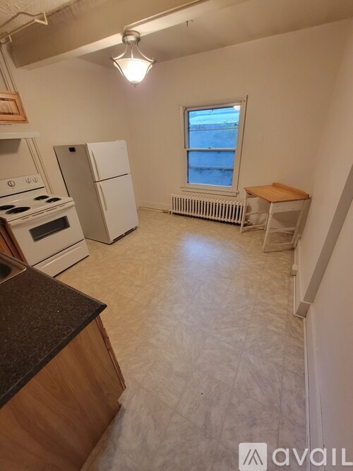 A kitchen with white appliances and a window.