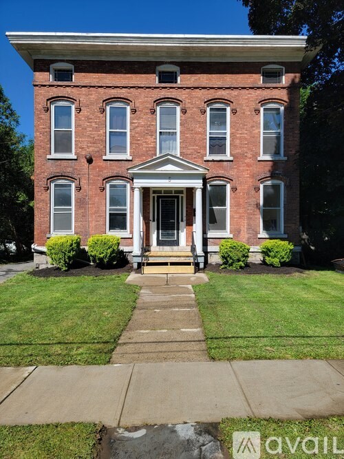 A red brick house with a white door and windows.