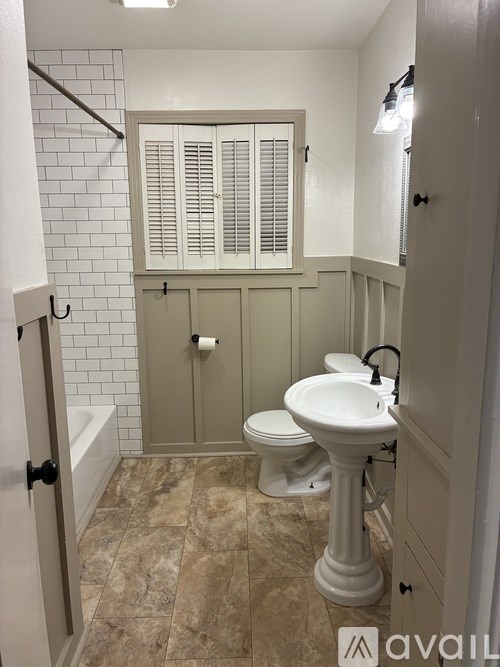 A bathroom with a toilet, sink, and bathtub.