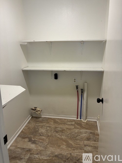 A room with a white wall and a tile floor.