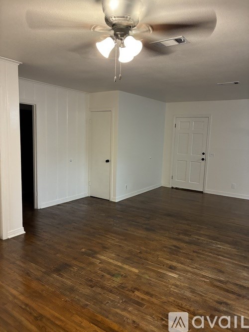 A room with wooden floors and a ceiling fan.