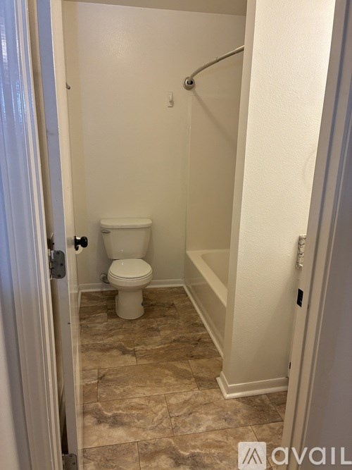 A small bathroom with a toilet and a shower stall.