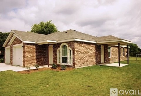 A house with a brick exterior and a large front yard is for sale.