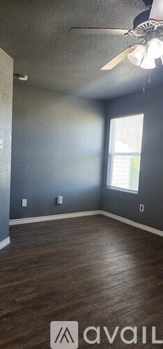A room with a ceiling fan and a window.