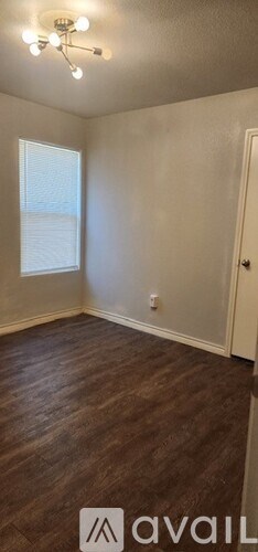 A room with wooden flooring and a window.