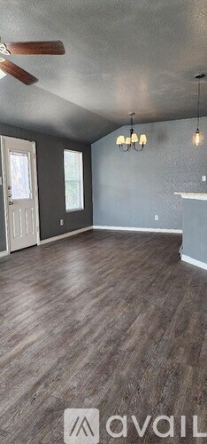 A room with wooden flooring and a ceiling fan.