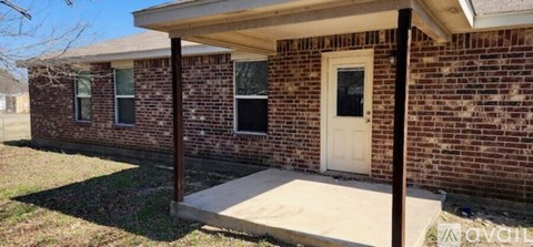 A brick house with a white door and windows.
