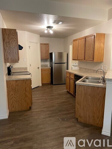 A kitchen with wooden cabinets and a refrigerator.