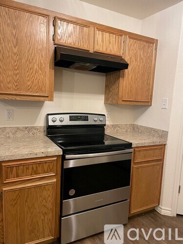 A kitchen with wooden cabinets and a stainless steel oven.