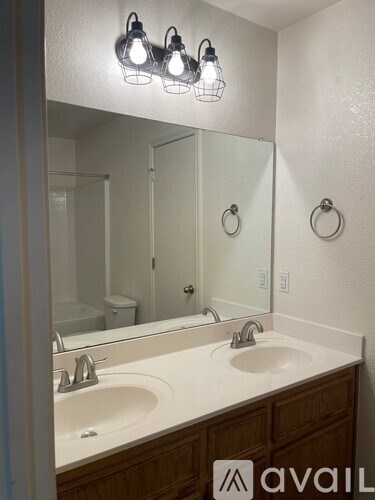 A bathroom with a double sink and a mirror above it.