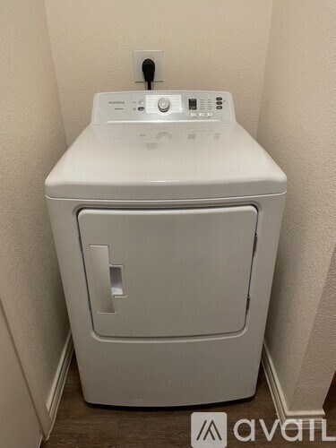 A white washing machine in a small room.