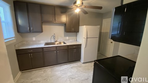 A kitchen with brown cabinets and a white fridge.