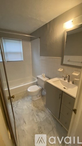 A bathroom with a toilet, sink, and mirror.
