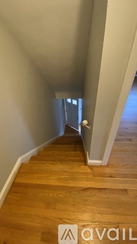 A hallway with wooden floors and white walls.