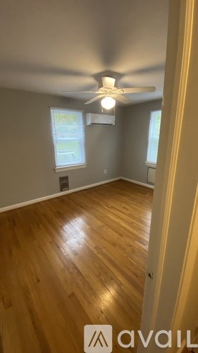 A room with wooden flooring and a ceiling fan.