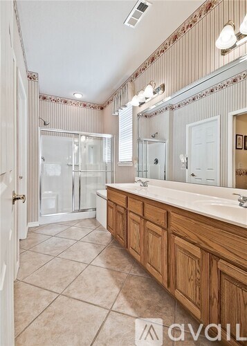 A bathroom with a large mirror and wooden cabinets.