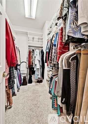 A walk in closet with clothes and shoes.