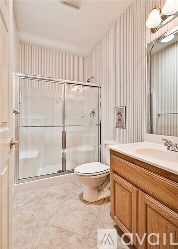 A bathroom with a toilet, sink, and walk-in shower.