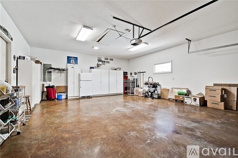A large empty room with a brown floor and white walls.