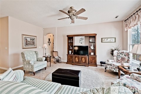 A living room with a striped sofa and a wooden entertainment center.