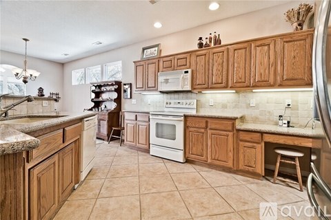 A kitchen with wooden cabinets and white appliances.