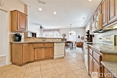 A kitchen with wooden cabinets and a tile floor.