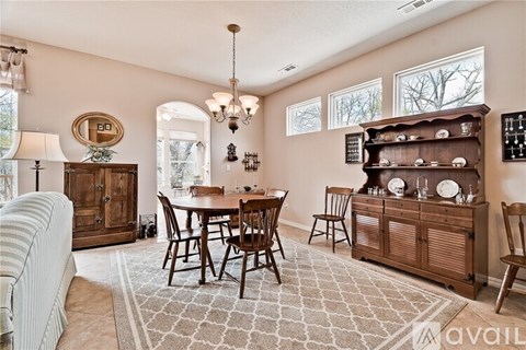 A dining room with a wooden table and chairs.