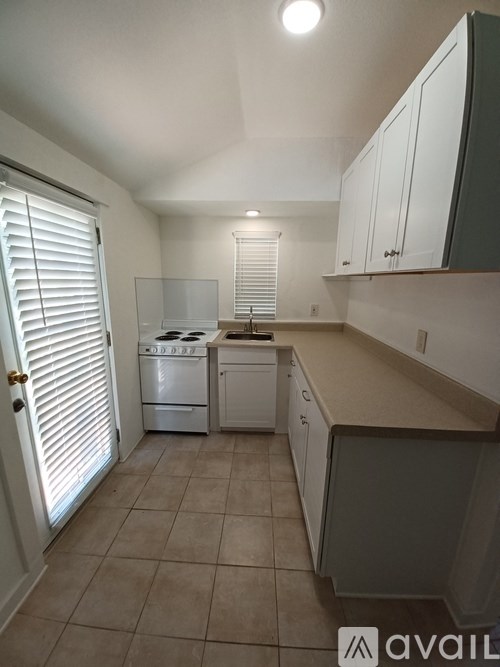 A kitchen with white appliances and cabinets.