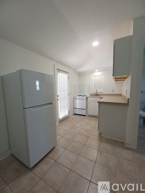 A kitchen with a refrigerator, dishwasher, and a countertop.