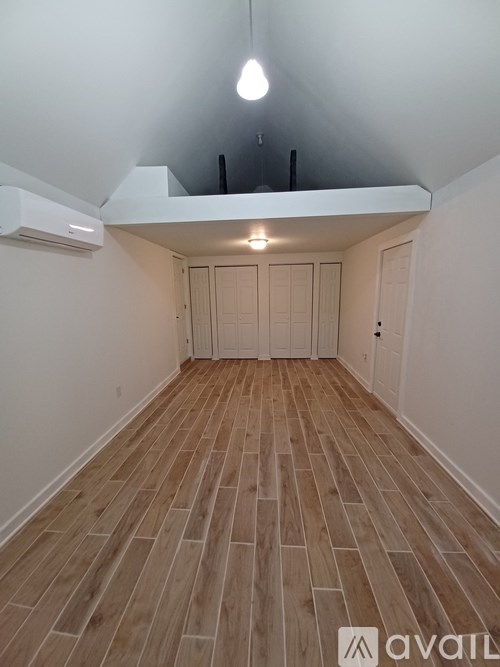 A room with wooden flooring and a white ceiling.