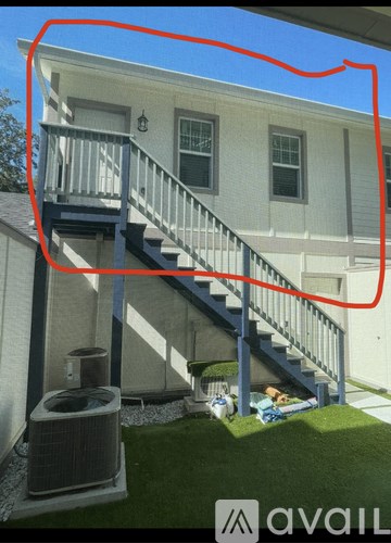 A house with a staircase and an air conditioning unit.
