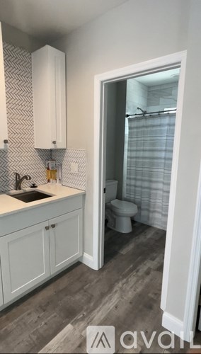 A bathroom with a sink, toilet, and shower.