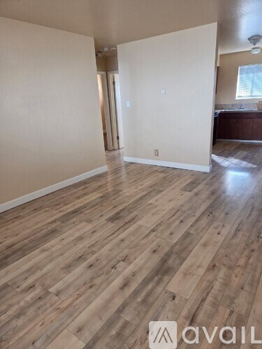 A room with wooden flooring and white walls.