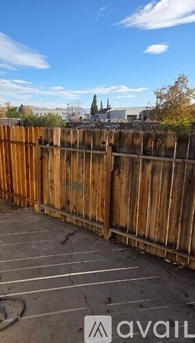 A wooden fence in front of a parking lot with a sign that says "available".