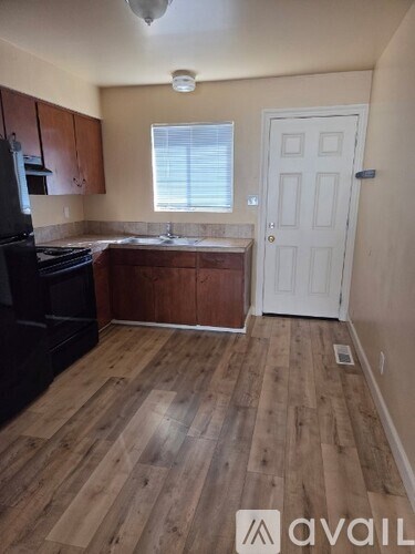 A kitchen with wooden floors and a white door.