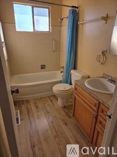 A bathroom with wooden floors and a white toilet.