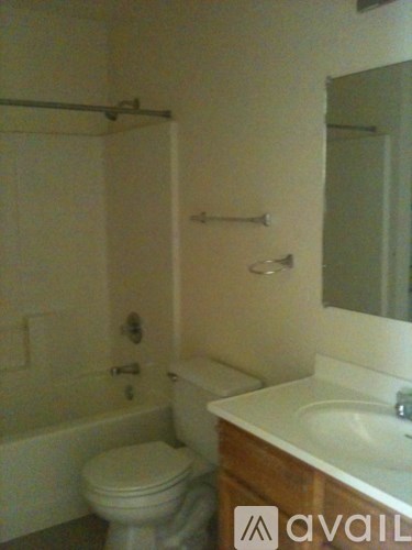 A white toilet sits next to a white sink in a small bathroom.