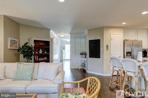 A living room with a white couch and a wooden chair.