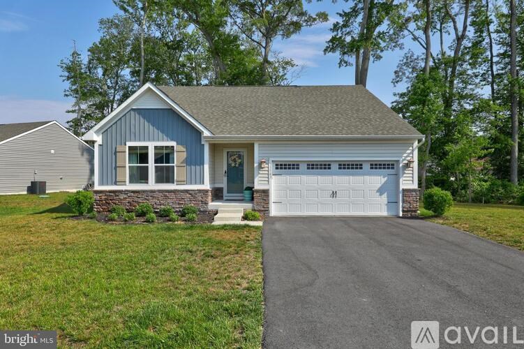 A house with a blue roof and a white garage door is for sale.