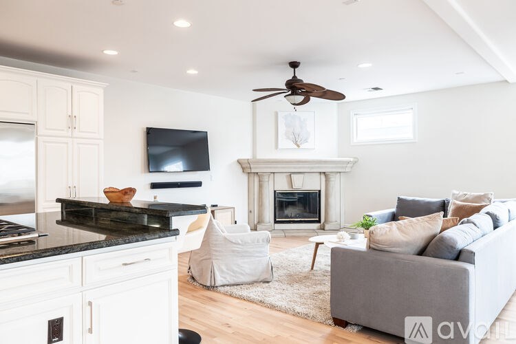A modern living room with a fireplace and a grey sofa.