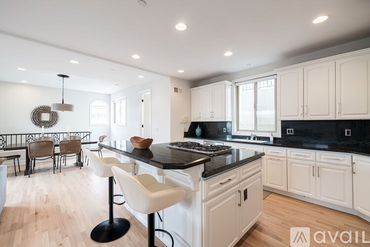 A modern kitchen with white cabinets and a black island.