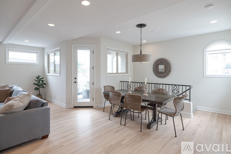 A dining room with a grey couch and a wooden table.