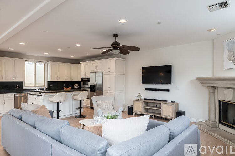 A living room with a grey couch and a fireplace.