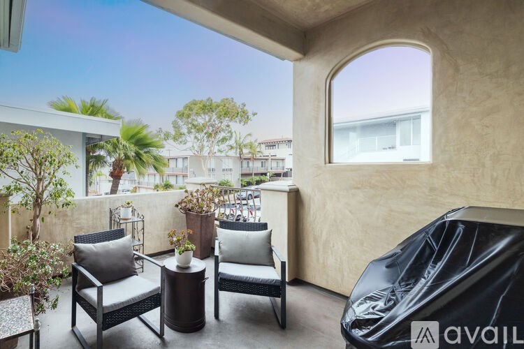 A balcony with a table and chairs overlooking a street.