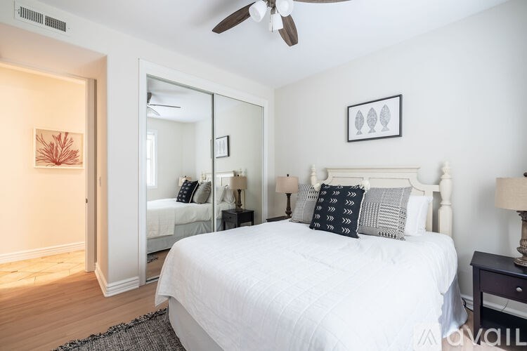 A bedroom with a large bed and a ceiling fan.
