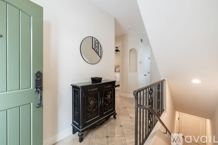 A black cabinet with gold designs sits in a hallway.
