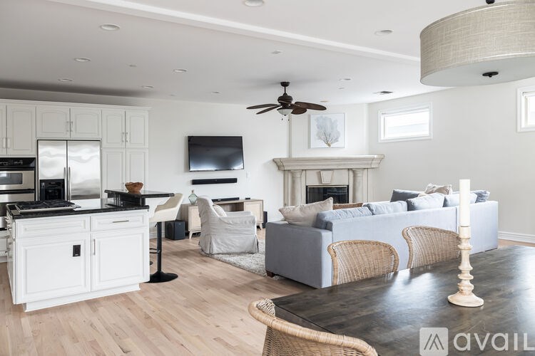 A modern living room with a fireplace and a kitchen area.