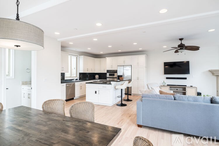 A modern open plan living and kitchen area with a grey sofa.
